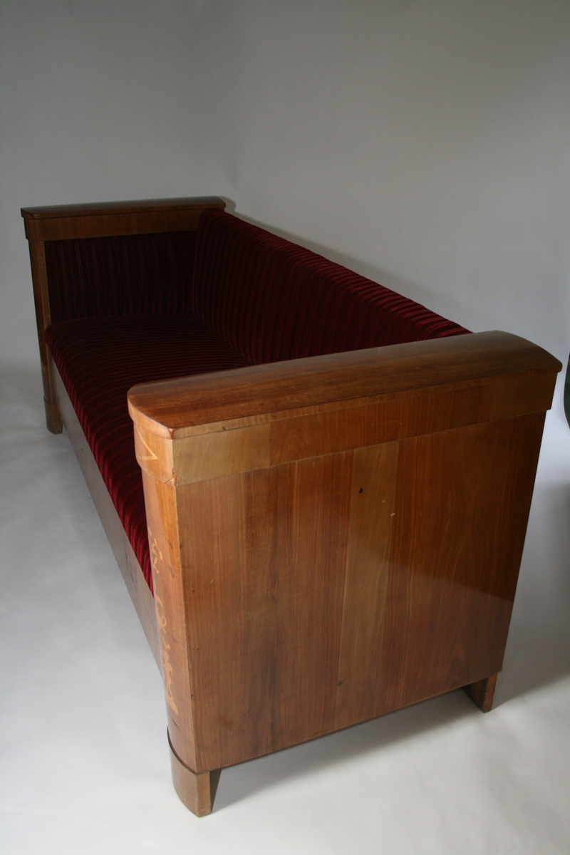 Med leddiker, intarsia - kjeruber med urner.  To lokk på rom i venstre leddik.
Trukket i dyp rød velur. Trekket er ikke opprinnelig