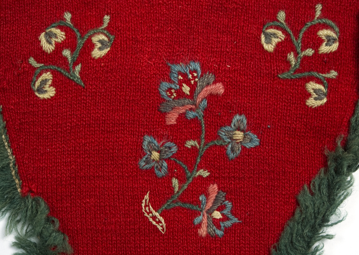 Rød stikket fingervante av ull, dekor av broderi og fryns.