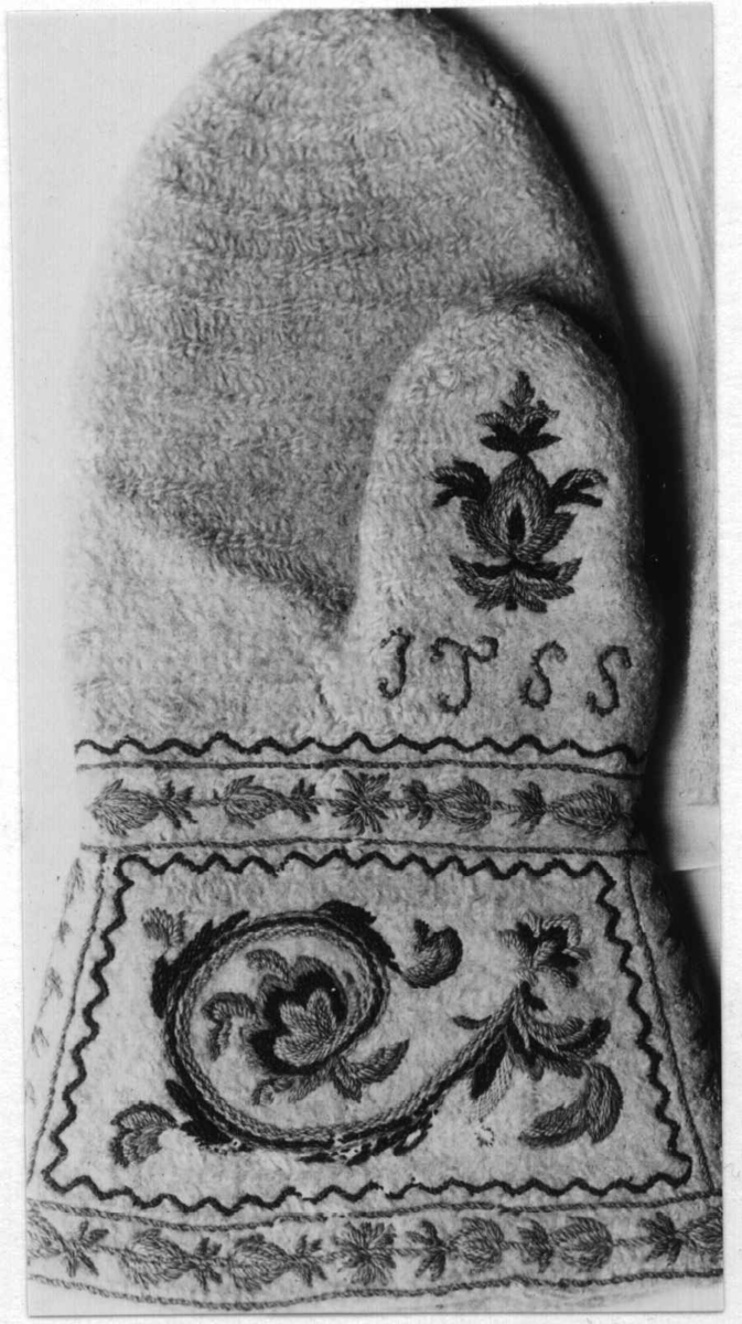 Hvite votter i nålebinding av ull med flerfaget broderi som dekor.