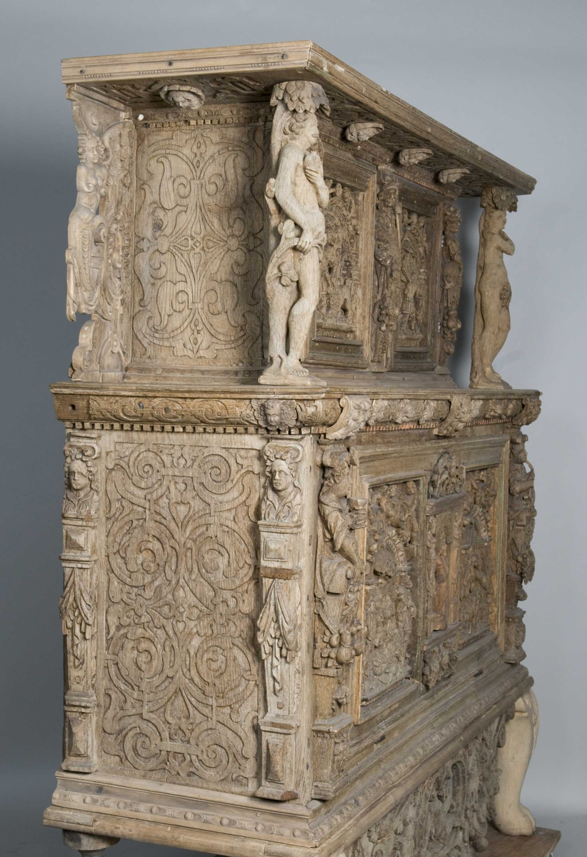 Rektangulært skap med skåret ornamentikk i flere deler. Øvre skap med to dører og gesims. Nedre skap med en klaff fremstilt som to dører. Skapdelene står på en sokkel med fire ben. Tympanon på øvre skap. Skapet ble opprinnelig brukt som skjenk med åpen klaff for å servere drikkevarer til gjester.
På overskapet i dørfyllinger er utskåret motiv fra gamle testament: "Samsons kamp med løven" og "Samson bærer bort Gazas byport". På underskap i fyllinger: "Samson slår filisterne med asenkjeven" og "Samson og Dalila". Dørene blir flankert av hermenpilaster. Mellom fyllinger på overskap aedikula med dyden "kjærlighet".  Som karyatide og atlant to utskårete figuerer "Adam og Eva" ved overskap. 
Klassiske profiler med eggstav, perlestav og tannsnitt. Beslagverkornament på skapsidene, gesimsens underside og profil på underskap. 
Utskårete hoder av løver, engler, kvinner, masker på gesimsens underside og profil på underskap. Sidebrett med hermer, portretter i medaljonger og beslagverk. Sokkelen består av dreide og utskårete ben, holdt av en ramme, Forsidens blending er dekorert med utskårete figurer og ornamenter i ørebruskstil.
Flere deler er sekundære.