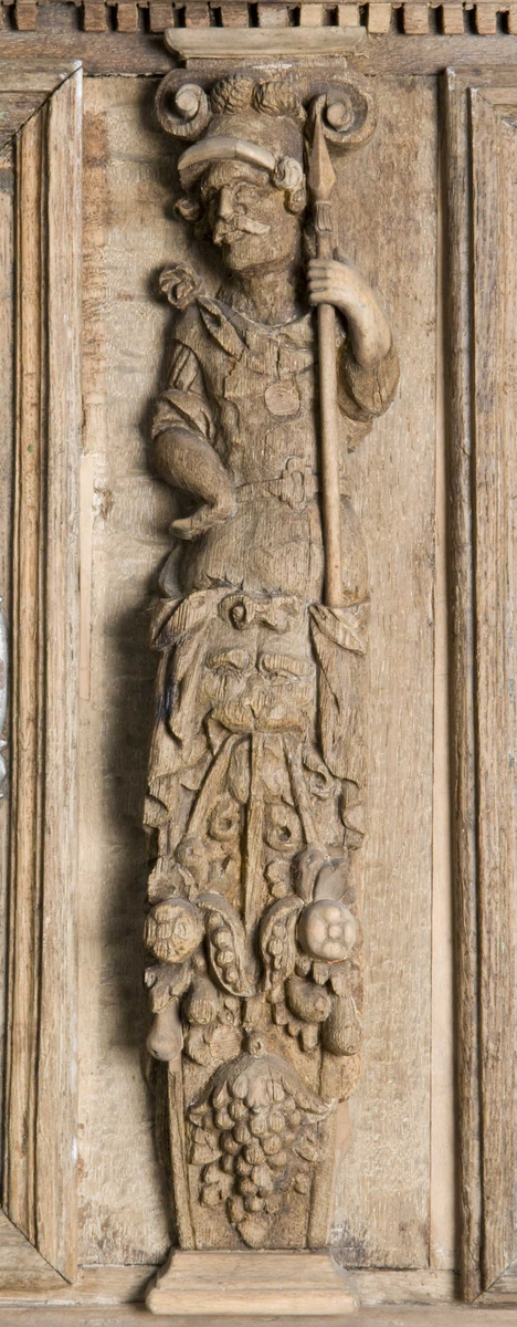 Rektangulært skap med skåret ornamentikk i flere deler. Øvre skap med to dører og gesims. Nedre skap med en klaff fremstilt som to dører. Skapdelene står på en sokkel med fire ben. Tympanon på øvre skap. Skapet ble opprinnelig brukt som skjenk med åpen klaff for å servere drikkevarer til gjester.
På overskapet i dørfyllinger er utskåret motiv fra gamle testament: "Samsons kamp med løven" og "Samson bærer bort Gazas byport". På underskap i fyllinger: "Samson slår filisterne med asenkjeven" og "Samson og Dalila". Dørene blir flankert av hermenpilaster. Mellom fyllinger på overskap aedikula med dyden "kjærlighet".  Som karyatide og atlant to utskårete figuerer "Adam og Eva" ved overskap. 
Klassiske profiler med eggstav, perlestav og tannsnitt. Beslagverkornament på skapsidene, gesimsens underside og profil på underskap. 
Utskårete hoder av løver, engler, kvinner, masker på gesimsens underside og profil på underskap. Sidebrett med hermer, portretter i medaljonger og beslagverk. Sokkelen består av dreide og utskårete ben, holdt av en ramme, Forsidens blending er dekorert med utskårete figurer og ornamenter i ørebruskstil.
Flere deler er sekundære.