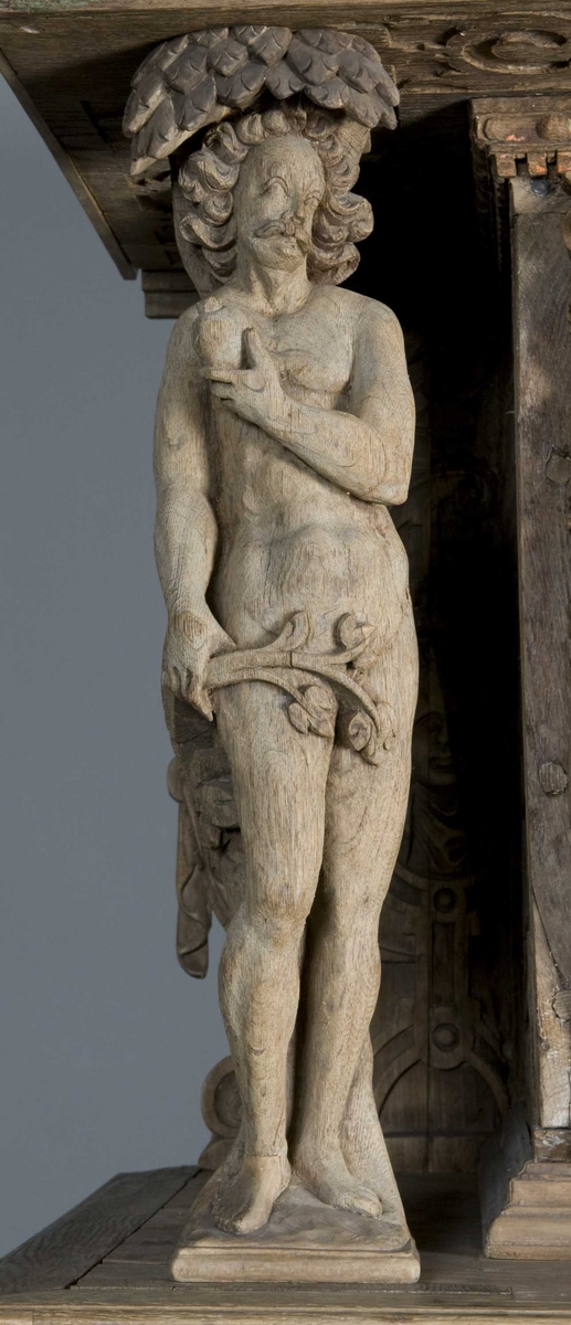 Rektangulært skap med skåret ornamentikk i flere deler. Øvre skap med to dører og gesims. Nedre skap med en klaff fremstilt som to dører. Skapdelene står på en sokkel med fire ben. Tympanon på øvre skap. Skapet ble opprinnelig brukt som skjenk med åpen klaff for å servere drikkevarer til gjester.
På overskapet i dørfyllinger er utskåret motiv fra gamle testament: "Samsons kamp med løven" og "Samson bærer bort Gazas byport". På underskap i fyllinger: "Samson slår filisterne med asenkjeven" og "Samson og Dalila". Dørene blir flankert av hermenpilaster. Mellom fyllinger på overskap aedikula med dyden "kjærlighet".  Som karyatide og atlant to utskårete figuerer "Adam og Eva" ved overskap. 
Klassiske profiler med eggstav, perlestav og tannsnitt. Beslagverkornament på skapsidene, gesimsens underside og profil på underskap. 
Utskårete hoder av løver, engler, kvinner, masker på gesimsens underside og profil på underskap. Sidebrett med hermer, portretter i medaljonger og beslagverk. Sokkelen består av dreide og utskårete ben, holdt av en ramme, Forsidens blending er dekorert med utskårete figurer og ornamenter i ørebruskstil.
Flere deler er sekundære.