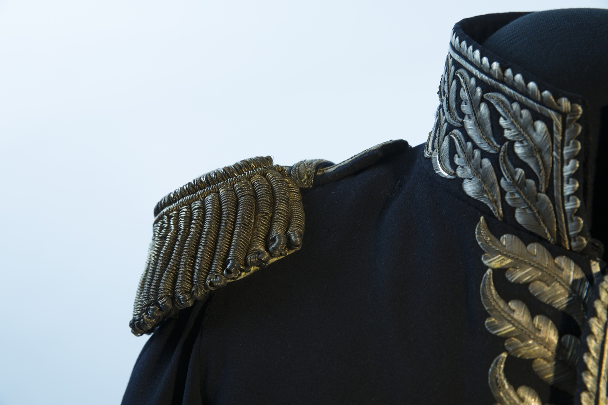 Mørkblå frakk med dekor av metallbroderi.