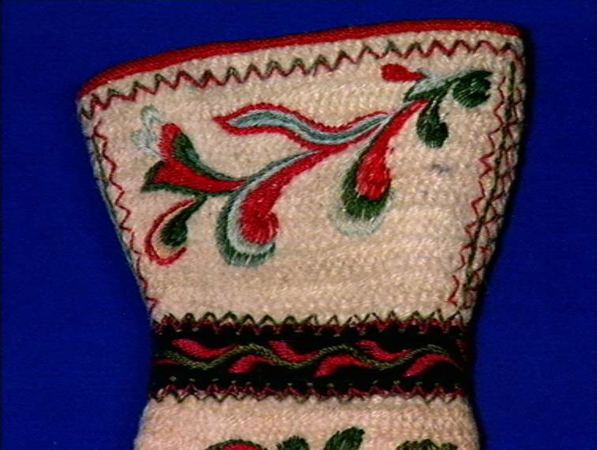 Hvite votter i nålebinding med dekor ab broderi og applikasjon.