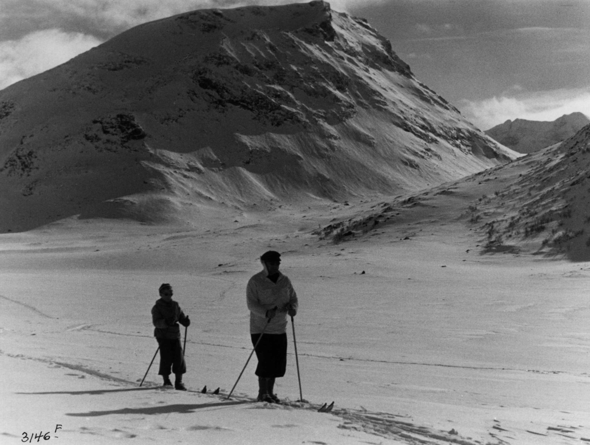 Skiløpere ved Styggehø i Jotunheimen med snødekte fjell og sol.