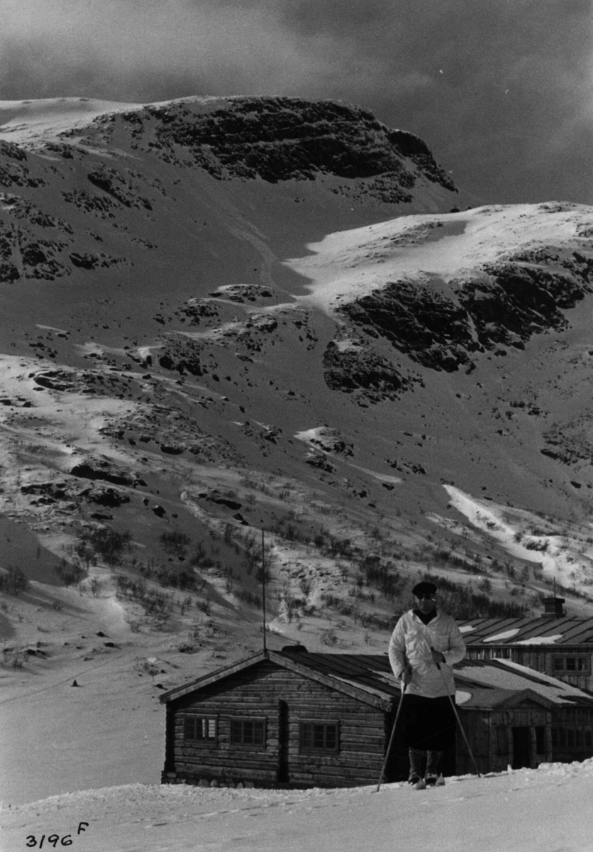 Skiløper ved Spiterstulen i Visdalen i Jotunheimen med snødekte fjell.