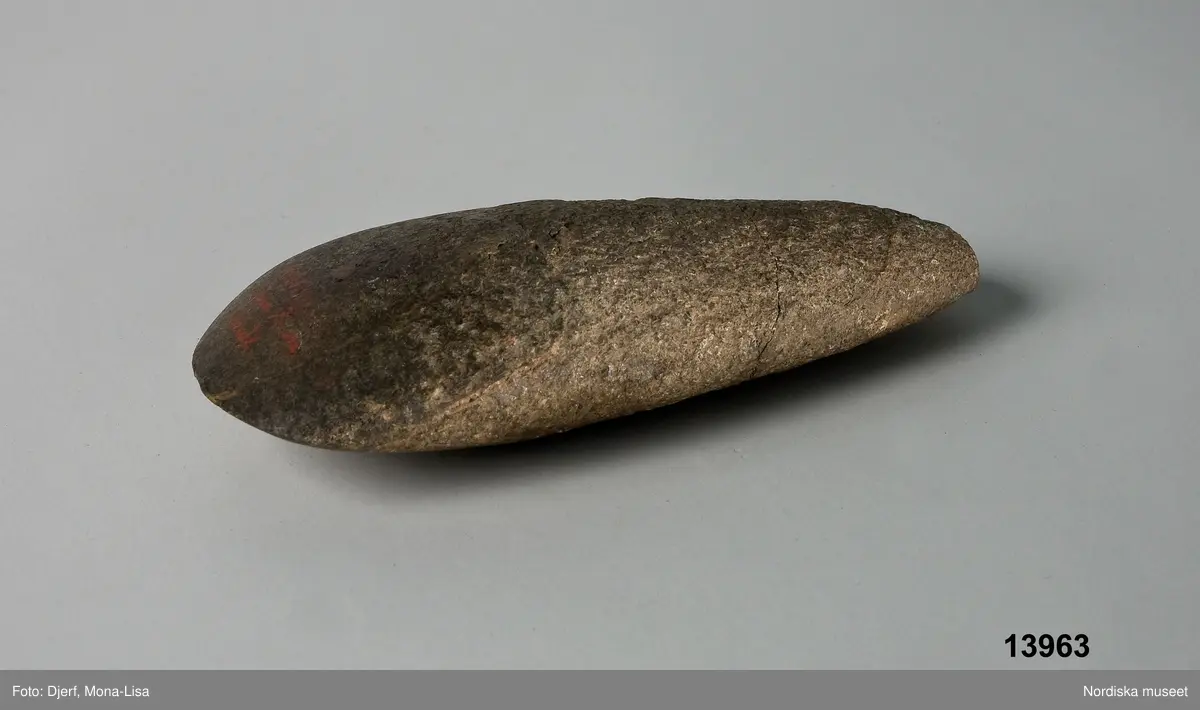 Huvudliggare:
"Yxa fr. Södra Vi sn. Åskvigg kallad; afknackad sten; tvåsidig och platt med rund egg. Utan hål 14,5 cm. l., 6 cm. br. i eggen. 'Funnen på gården Nr 5 Södra Vis kyrkobys ägor vid en nyodling omkring 900 fot söder om gården, 9 tum under jordytan, vid plöjning. Den fans 1871.'
G. ss. 13,962."

Bilaga 
Inget utöver huvudliggaren [förutom att föremålet benämns "Stenmäjsel af gråsten".)

Ur "Svensk forntro och folksed i bild och ord", 1920, N.E.Hammarstedt, Stockholm. s. 14:
"ÅSK-VIGGAR
ÅSK-VIGGAR, tor-viggar eller tor-blegar kallas av allmogen i åtminstone de flesta av våra landskap i jorden funna stenåldersredskap, företrädesvis stenyxor, såväl borrade som även oborrade. men även andra om dylika mer eller mindre erinrrande naturformade stenar erhålla ofta denna benämning. Det troddes, att en sådan åskvigg nedföll vid varje åskslag, men nedträngde så djupt (sju alnar eller sju famnar) i jorden, att den först efter flera (vanligen sju) år kom i dagen. Dylika åskviggar tillskriver man ännu i åtskilliga orter stor kraft i flera hänseenden. Ofta skrapade man även pulver av dem för att använda det som läkemedel (jfr älvkvarnar och älvstenar)."
