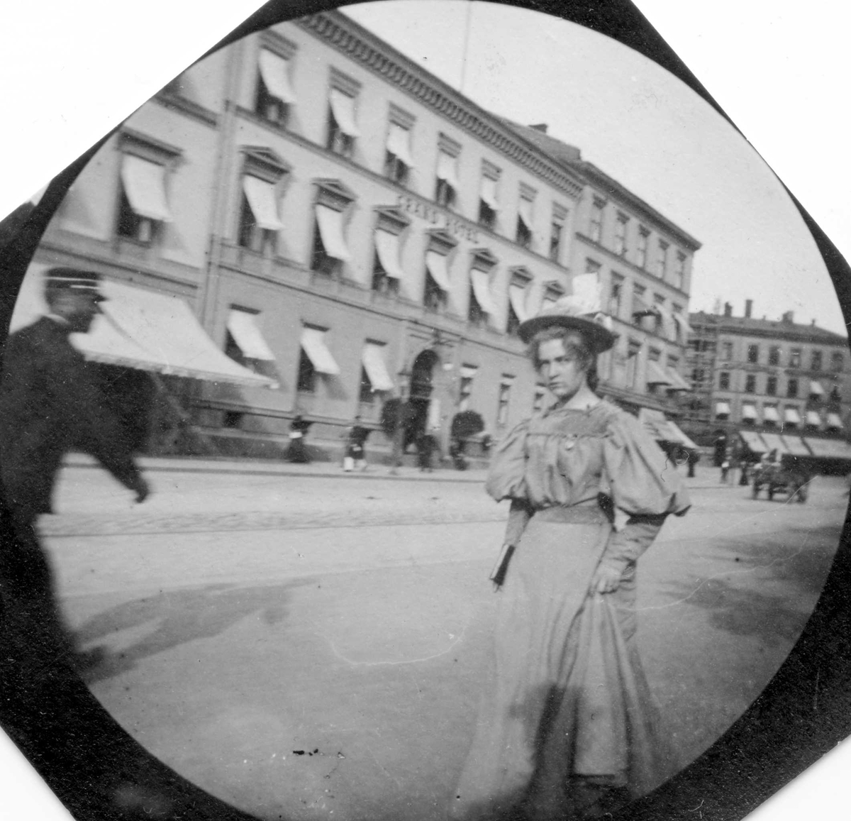 Frk. Herlofsen spaserer langs Karl Johans gate, Oslo, med Grand Hotel på den andre siden.