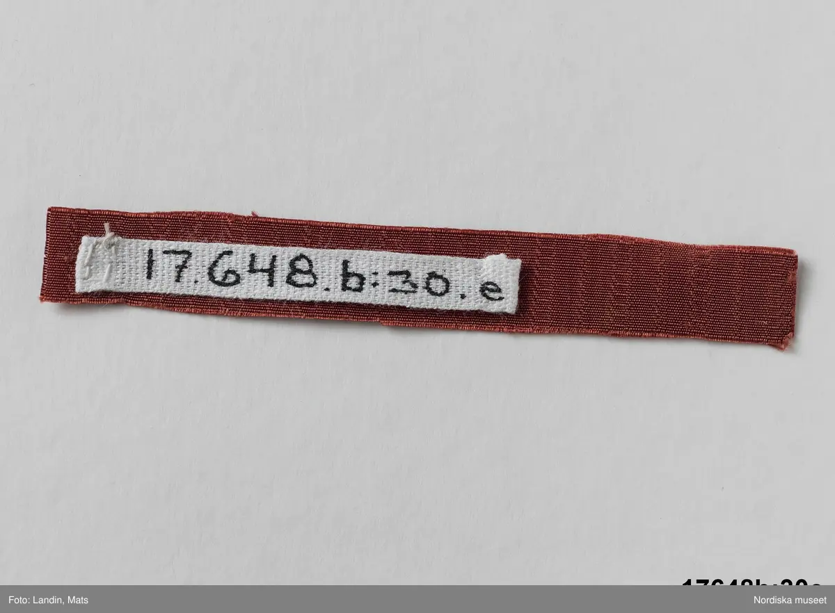 Beskrivning gällande NM.0017648B:30a-f:
" 'Faconerat Gros di tour', siden, Sverige, 6 prover. Siden i mönstrad varprips. Varpen flotterar i mönstret över flera inslag. Prov a har ändmarkering med 'IAM. 231 (J. A. Meurman) invänvt i kanten. prov b-c är halvsiden.
Papper fäst vid prov a med texten 'Faconerat Grod di tour de 2ne för sig skiel sitjande är 1/2 siden."
Katalogisering ur: Stavenow-Hidemark, E. 1700-tals textil : Anders Berchs samling i Nordiska museet. Stockholm : Nordiska museet, 1990. sid 172