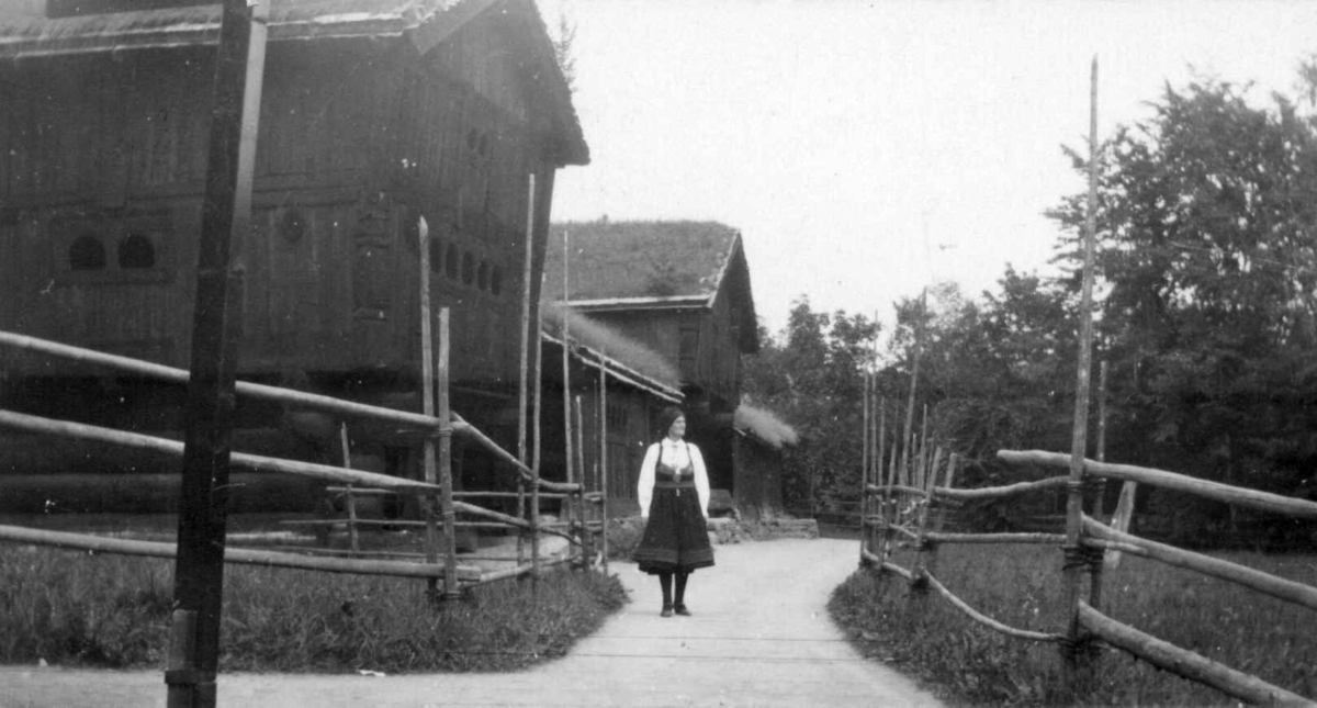 Setesdalstunet på Norsk folkemuseum, 1934. Gyro Skomedal foran husene.