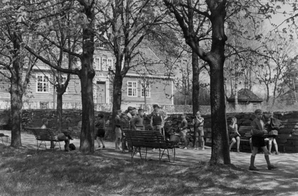 Skolebarn i allèen på Norsk folkemuseum, 1951. I bakgrunnen, prestegården fra Leikanger i Sogn (Thaulowmuseet).