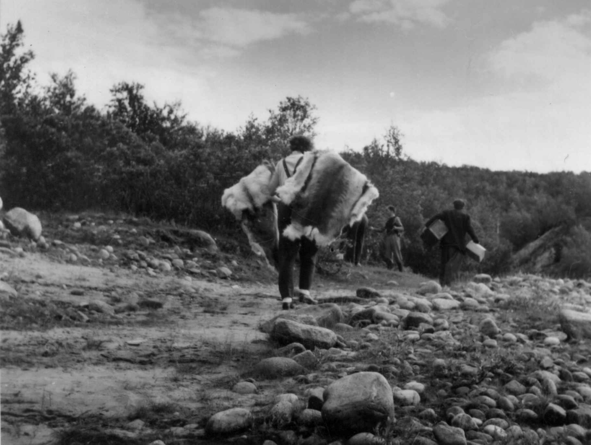 Folk bærer båt og bagasje forbi Storfossen og til en lastebil. Tanaelv 1952.