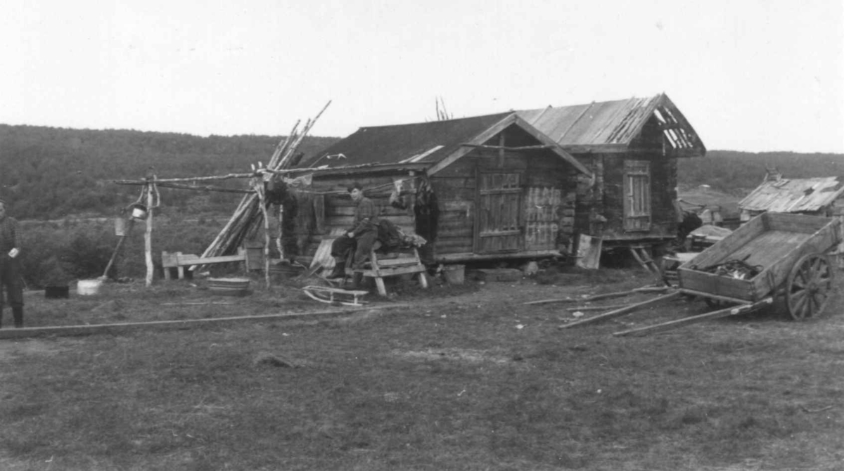 Nils Mathis Gaups gård. En person og en kjerre utenfor to stabbur. Masi 1953.
