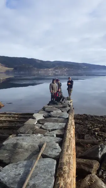 Fire menn er avbildet på en vorr. I bakgrunnen et fjordlandskap