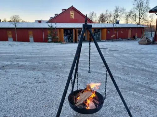 En bålpanne med bål utenfor stallen på Bygdø Kongsgård. 
