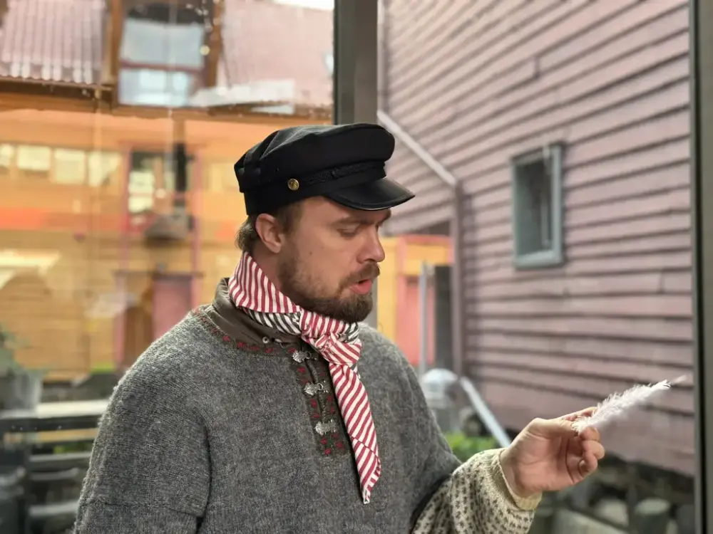 Vi ser Vidar Vraker som holder en hvit fjær