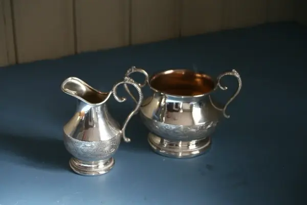 Bilder av en sølvkanne og sølvbolle. Gjenstandene er en del av Lågdalsmuseets samlinger. 