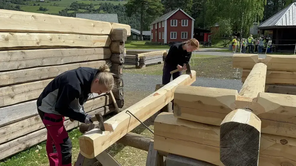 To jenter som hogger til tømmerstokk