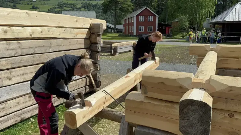 To jenter som hogger til tømmerstokk