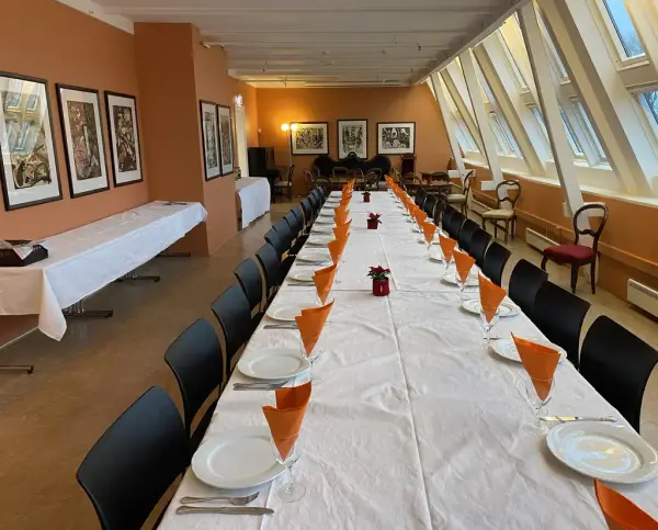 Et lang rom med et dekket langbord. 