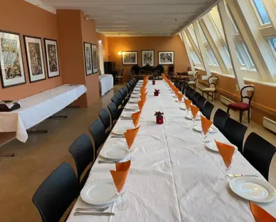 Et lang rom med et dekket langbord. 