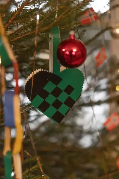 Detaljer fra et juletre: julekule, julekurv og lenke. 