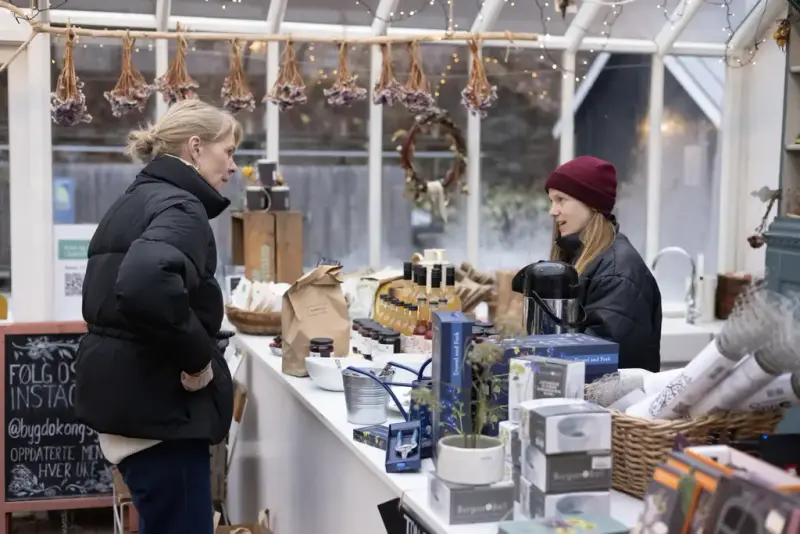 En dame handler i gårdsbutikken på Gartneriet. 