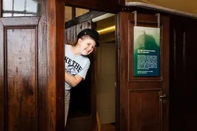 Jente med båtsmannslue stikker hodet fram fra styrhuset som i sin tid tilhørte dampskipet Tordenskjold. 