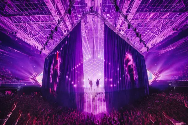 En gigantisk scene, publikum med armene i været, Karpe på scenen, lilla scenelys