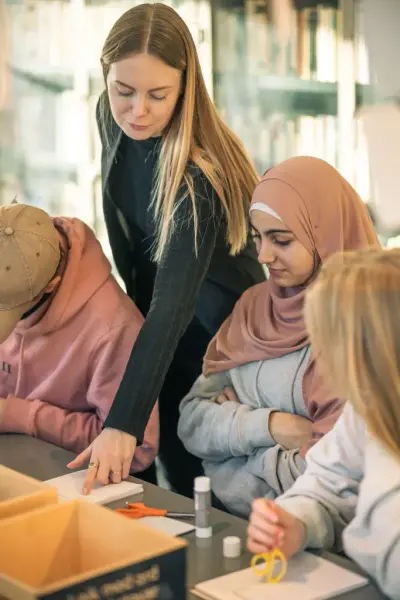 Tilsett som hjelper besøkande med ei oppgåve