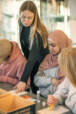 Tilsett som hjelper besøkande med ei oppgåve
