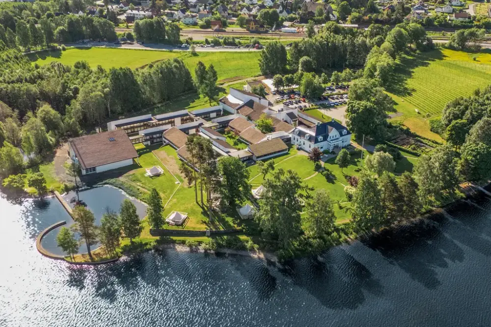 Flyfoto av Thorbjørnrud hotell som ligger langs vannet