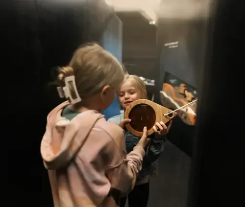 Fra utstillingen "Inn i berget". To barn forsker i utstillingen.