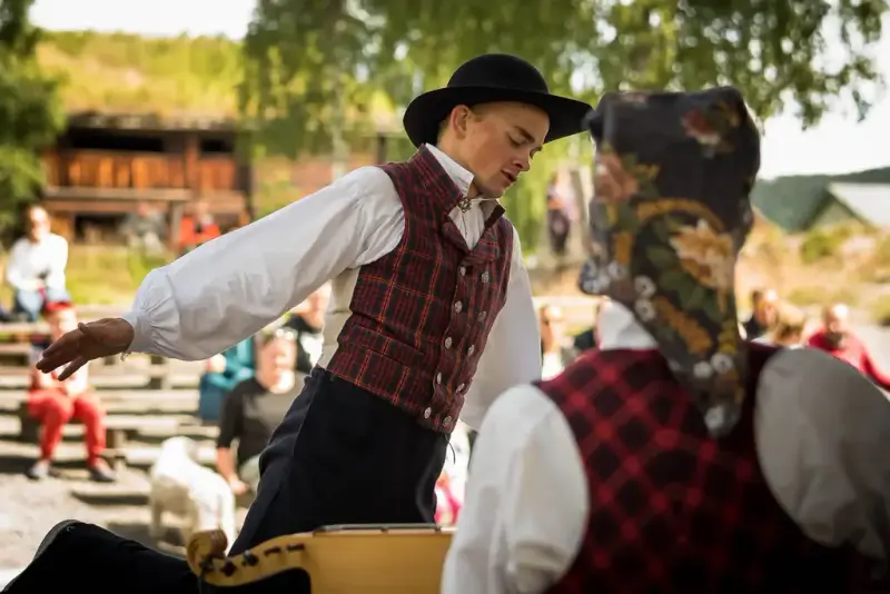 Ung mann i valdresbunad som danser til langeleikspill