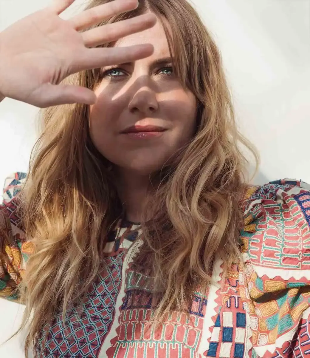 Portrett av Ingebjørg Bratland som skuggar for sola med den eine handa 