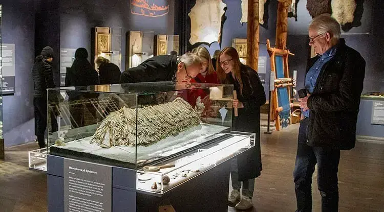Besökare tittar på monter i utställningen Forntidsresan på Västernorrlands museum