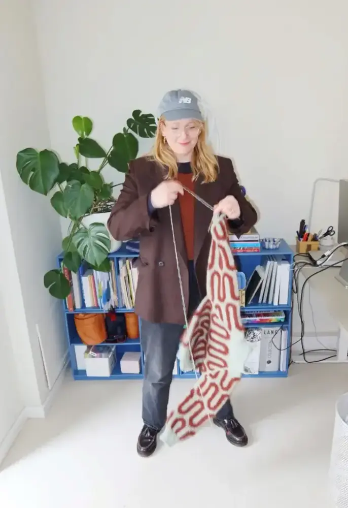 Strikkedesigner Mie Firring holder opp et strikketøy 