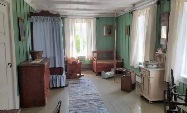 Soverom med seng og vugge og flere andre møbler.