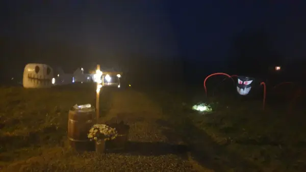 Mørk og våt kveld på prærien med ein diger edderkopp med stort glis og raude bein, og ein stor kvit hovudskalle. (Begge er dekorerte høyballar)