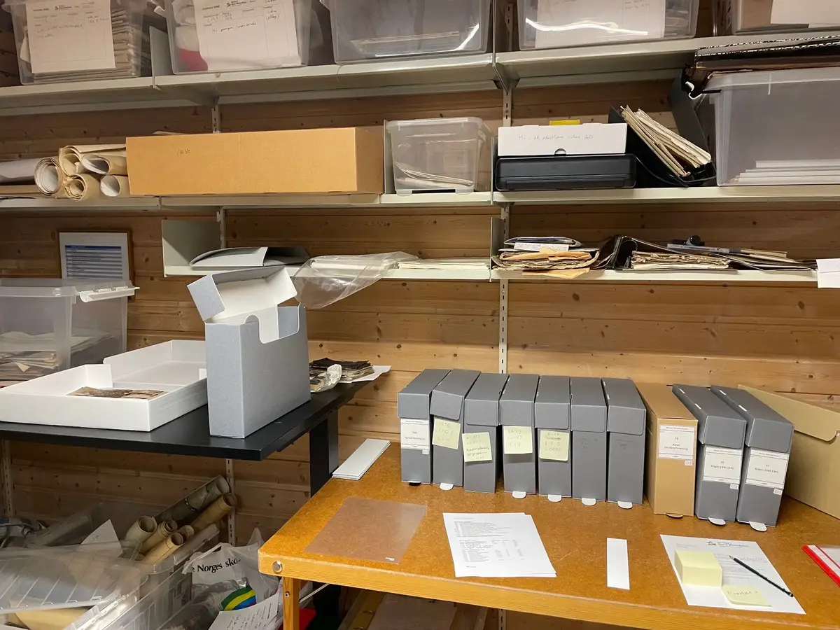 Flere hyller fylt med bokser, papirer, ruller og dokumenter