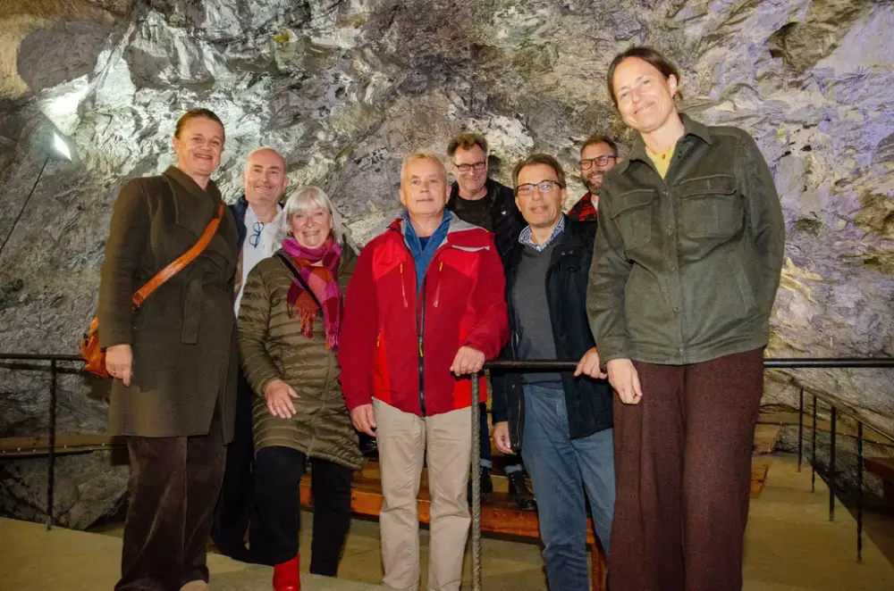 En gruppe personer står og smiler i en gruve