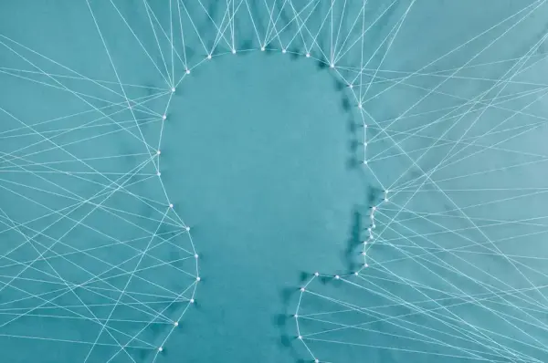 Illustrasjon med omriss av eit hovud i profil, danna av kvite trådar som er spente opp mellom stiftar. Turkis bakgrunn.