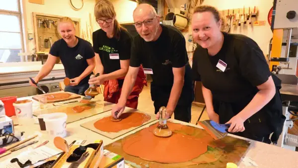 Bildet viser fire personer som smiler mot kamera