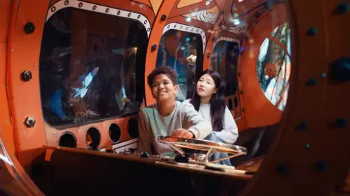 Two children inside a submarine installation in the Explore the Ocean exhibition at the Norwegian Maritime Museum.