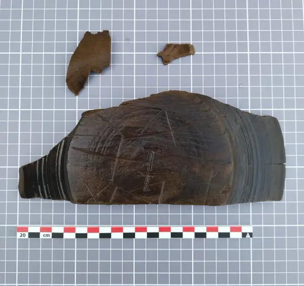 Fragment av dreid trebolle med innrisset bumerke, funnet i Bjørvika.