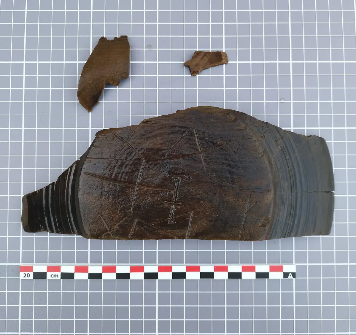 Fragment av dreid trebolle med innrisset bumerke, funnet i Bjørvika.