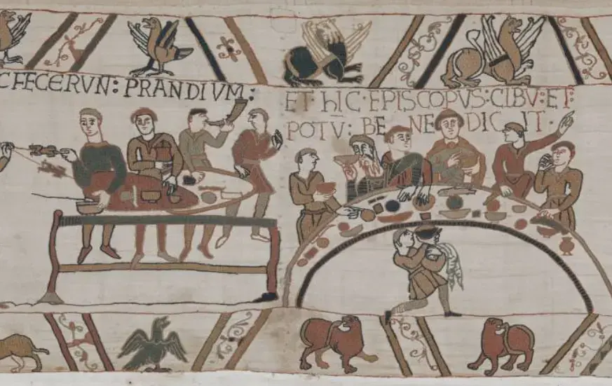 Utsnitt fra Bayeux-teppet som viser personer ved bord som spiser og drikker av skåler og beger.