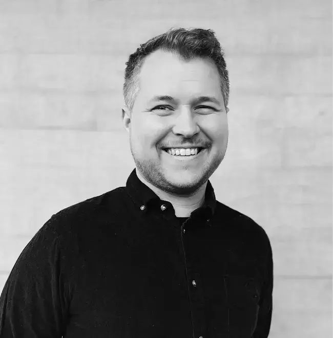 Fredrik Hope med svart skjorte framom ein murvegg