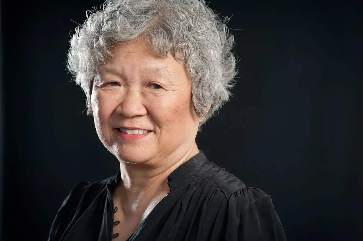 Portrettfoto av Anne Kyong Sook Øfsti med mørk bakgrunn