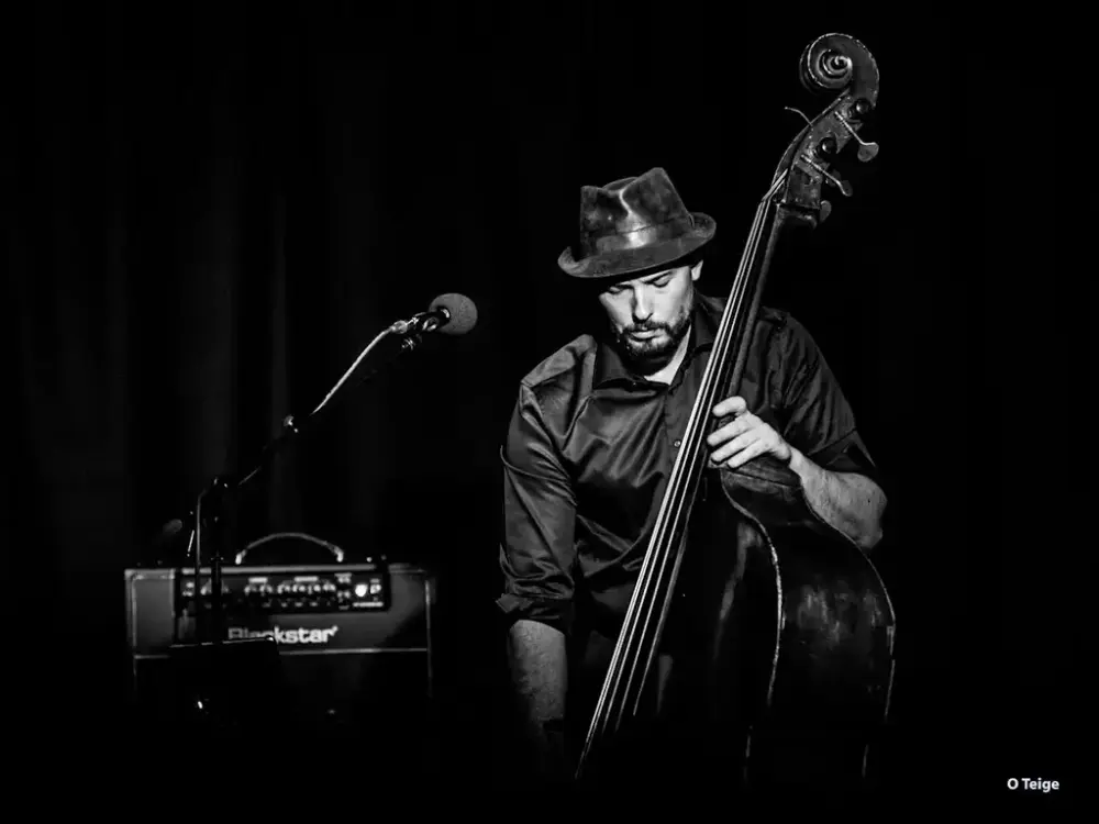 Portrettfoto av Steinar Raknes med kontrabass, mikrofon og forsterker